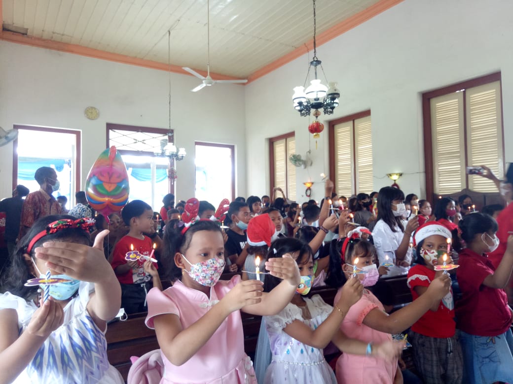 Anak-anak kristiani sa'at menyayikan lagu dengan mengangkat lilinnya