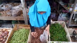 foto : Alif, pedagang pasar saat melayani pembeli bawang merah. Kamis (23/6/2022).